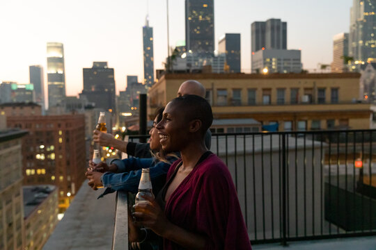 Friends Watch the Sunset and Drink On A Rooftop