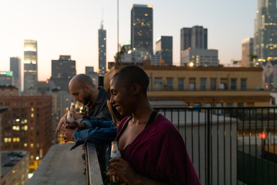 Friends Watch The City From A Rooftop