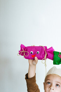 Toddler holding 2 handmade gifts with googly eyes
