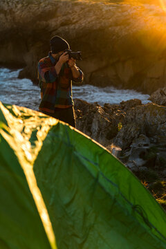 Adventure photographer taking pictures close to tent