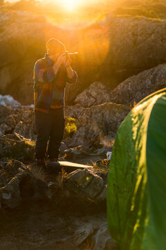 Adventure photographer taking pictures close to tent