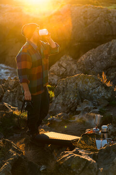 Photographer drinking hot drink campground