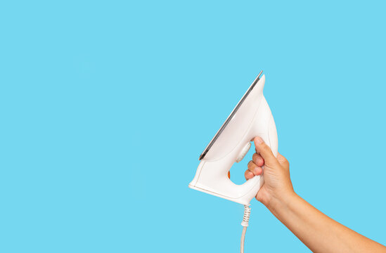 A iron in woman hand. spece for your text.