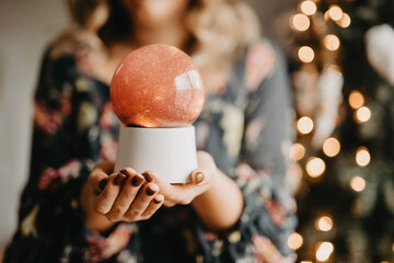 A woman holding a pink snow globe