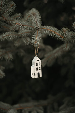 A Woman In Her 30s Hanging Christmas Ornaments On A Tree Outdoors