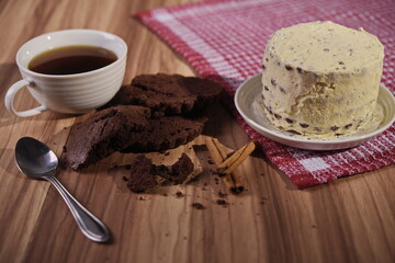 Brownie slices, buttercream cake, and a cup of coffee with cinnamon sticks on the table.
