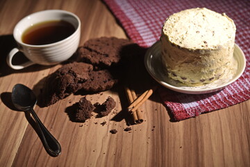 Brownie slices, buttercream cake, and a cup of coffee with cinnamon sticks on the table.