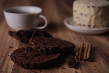 Brownie slices with buttercream and cinnamon sticks on the table.