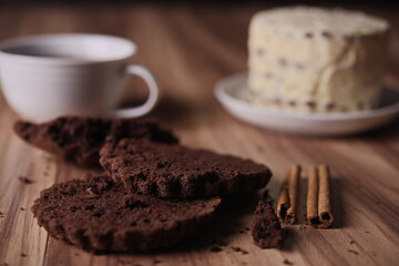 Brownie slices with buttercream and cinnamon sticks on the table.