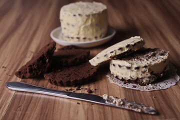 Fototapeta na wymiar Brownie slices, cream cake, and a knife on the table.