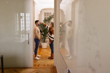 Woman measuring temperature for male friend during COVID pandemi