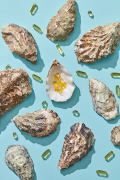 Pills in oysters shell on blue background