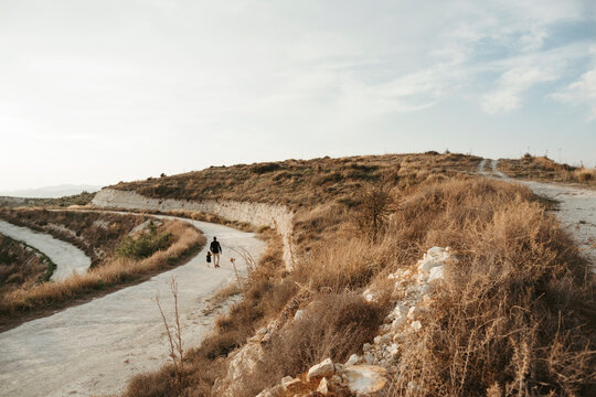 A father walking with a small daughter.