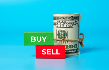 A picture fake money with Buy, Sell, green and red wooden block. Money, investment, foreign exchange and trading concept