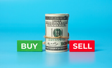 A picture fake money with Buy, Sell, green and red wooden block. Money, investment, foreign exchange and trading concept