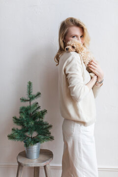 Happy woman is holding a little puppy on the shoulder