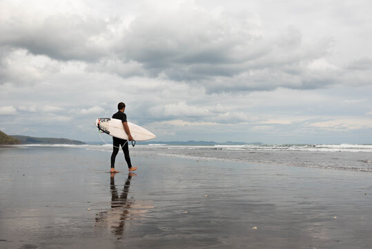 Surfer walking surfboard