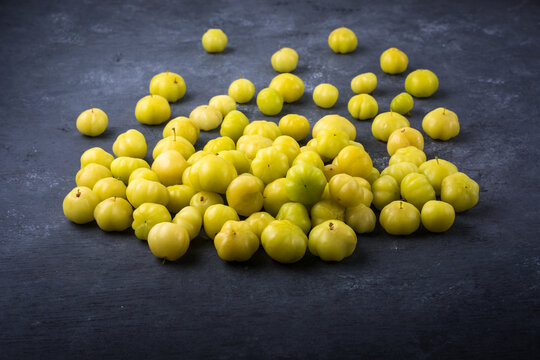 star gooseberry or starberry, also known as malay or country or west india or tahitian gooseberry, small star shaped waxy yellow tropical berries fruit scattered, closeup side view