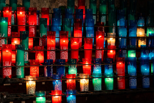 Arrangement of colorful lit candles in the dark