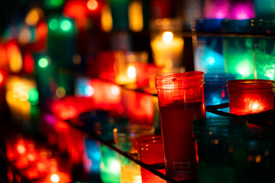 Arrangement of colorful lit candles in the dark