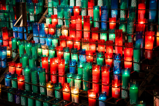 Arrangement of colorful lit candles in the dark