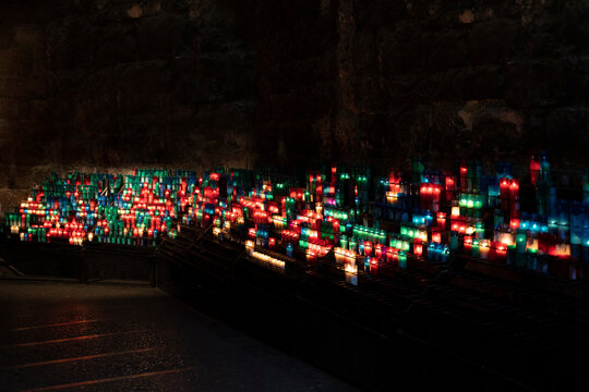 Arrangement of colorful lit candles in the dark