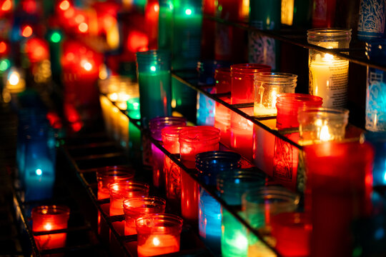 Arrangement of colorful lit candles in the dark