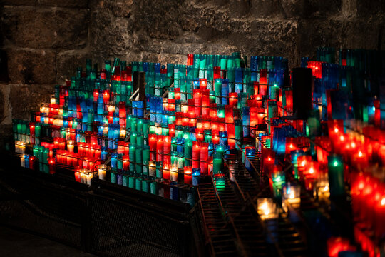 Arrangement of colorful lit candles in the dark