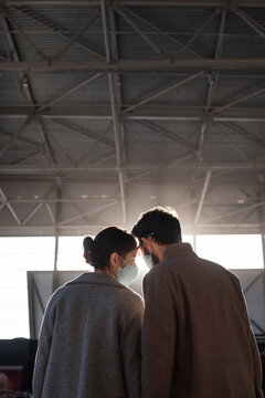 Couple in masks under station roof