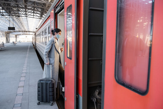 Female traveler in mask entering train