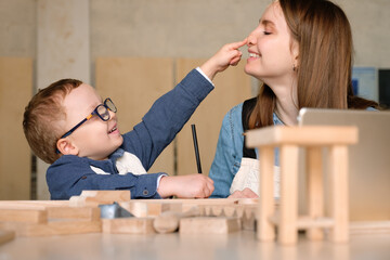Happy mother and son having fun in carpentry studio