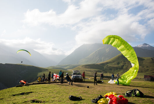 People gathering in hills during paragliding festival