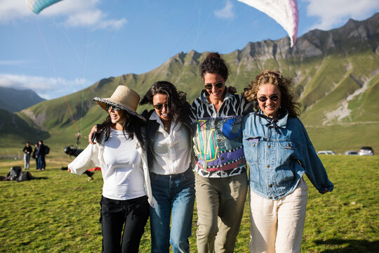Cheerful women during paragliding festival in highlands