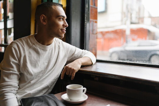 Young Man Using Computer Seated in a Coffee Shop