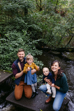 Young stylish family looking at the camera and smiling together