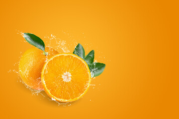 Water splashing on Orange juice freshly squeezed on an orange background.