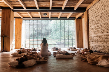 Instructor helping people to practice sleep yoga