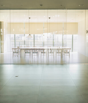 Conference room with a long wooden table, chairs and panoramic w