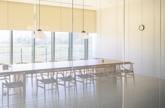 Conference room with a long wooden table, chairs and panoramic w