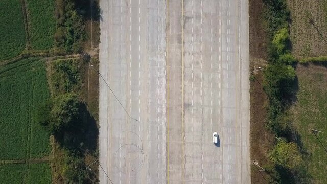 Single White Car driving along 14 Lane Highway Naypyidaw Myanmar Capital Aerial Top Shot