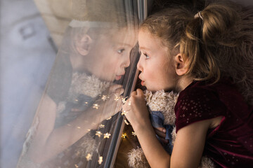 Girl on the windowsill with her favourite toy 