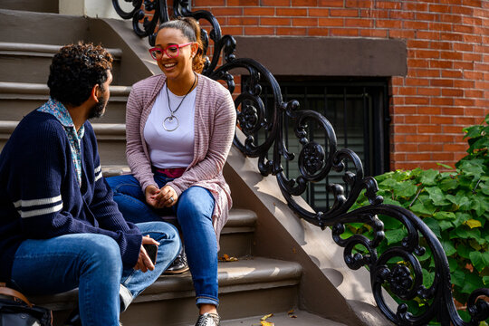 Young African American Relaxing on stoop of apartment steps 