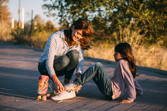 Mother and daughter with roller skates in park