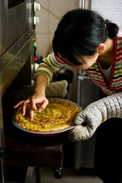 Chef's hand testing prepared sweet potatoes pie