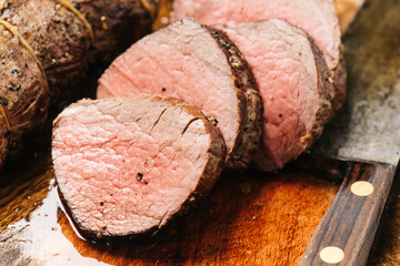Cutting cooked beef tenderloin into medallions