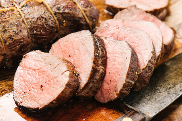 Cutting cooked beef tenderloin into medallions
