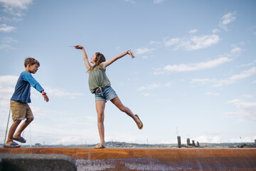 Girl poses while she balances on a beam outside