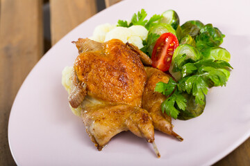 Fried quail-tobacco served with tasty vegetables and greens at plate