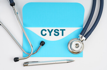 There is a stethoscope on the table, an envelope with paper on which it is written - CYST
