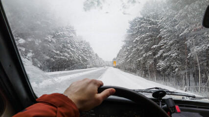 Unrecognizable driver steering car in countryside